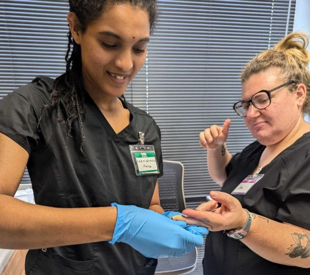 {{ school.name }} student practicing finger prick for blood draw