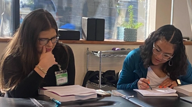 {{ school.name }} students reviewing workbook material