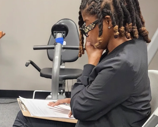 {{ school.name }} student reviewing paper work for a patient